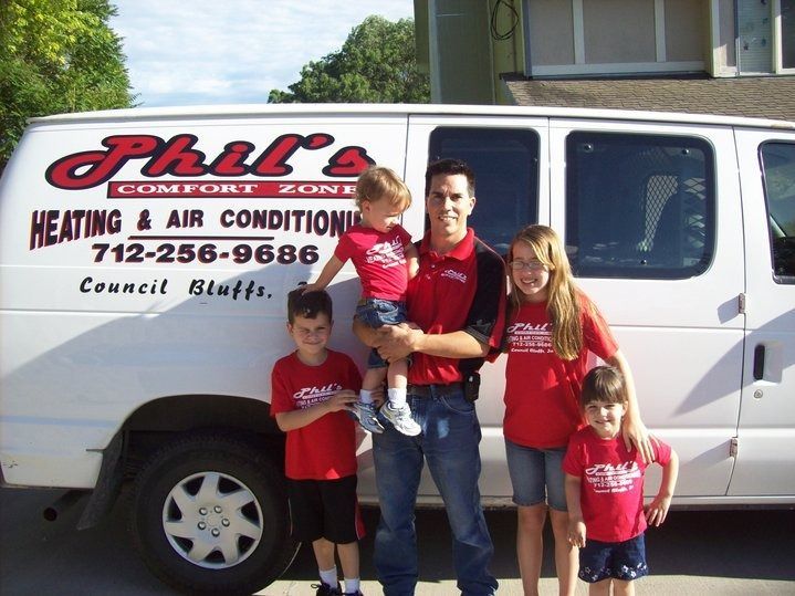 Man with four children stands beside a white van. 