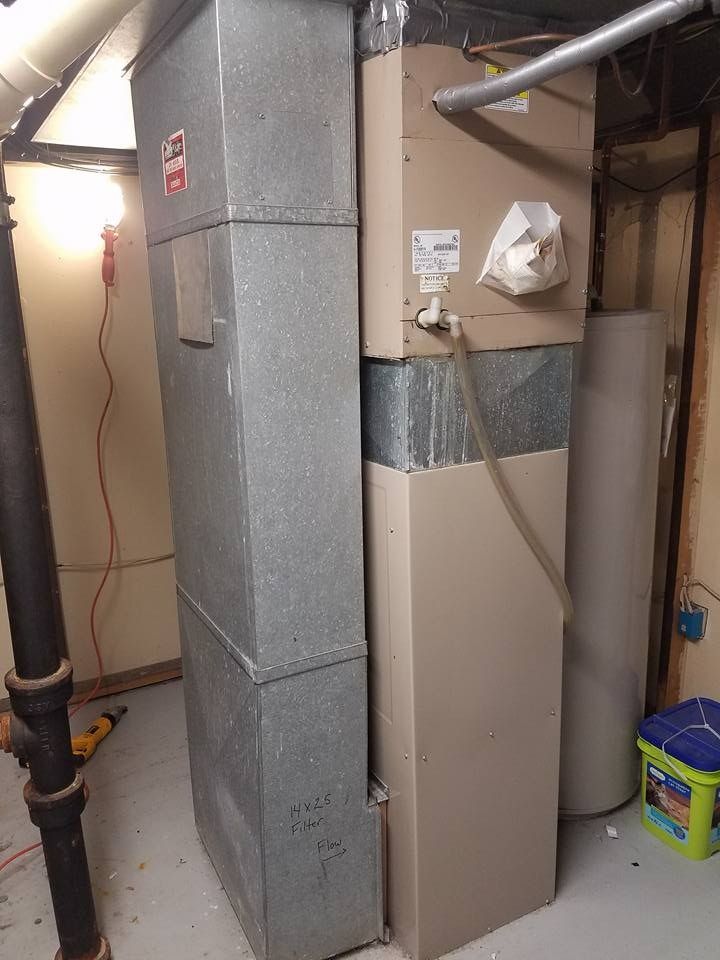 HVAC system with metal ductwork, in a basement setting.