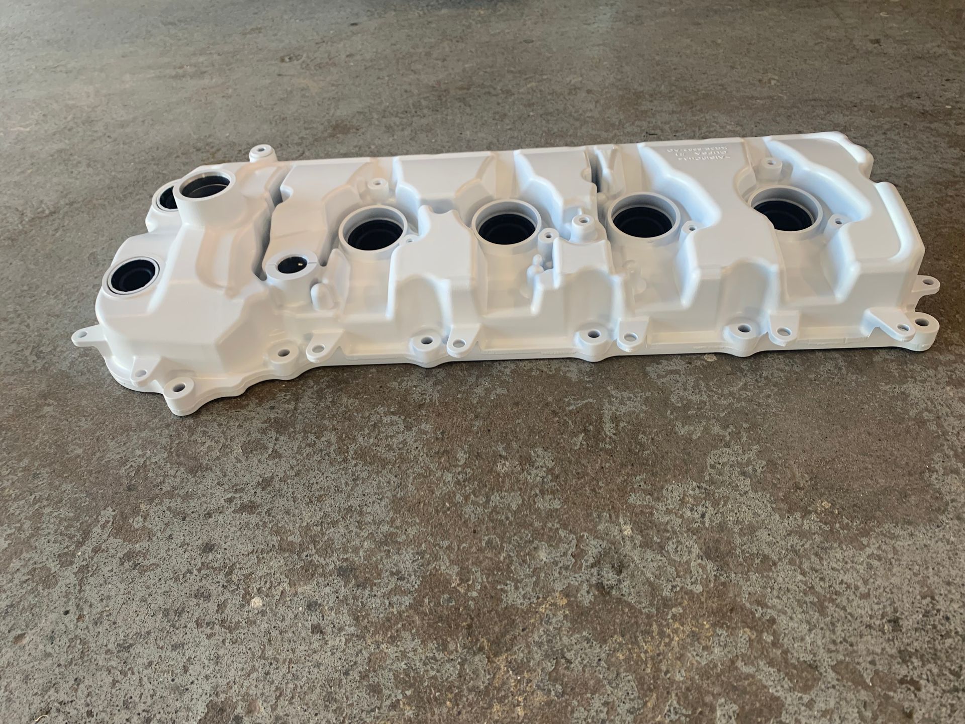 White engine valve cover on concrete floor
