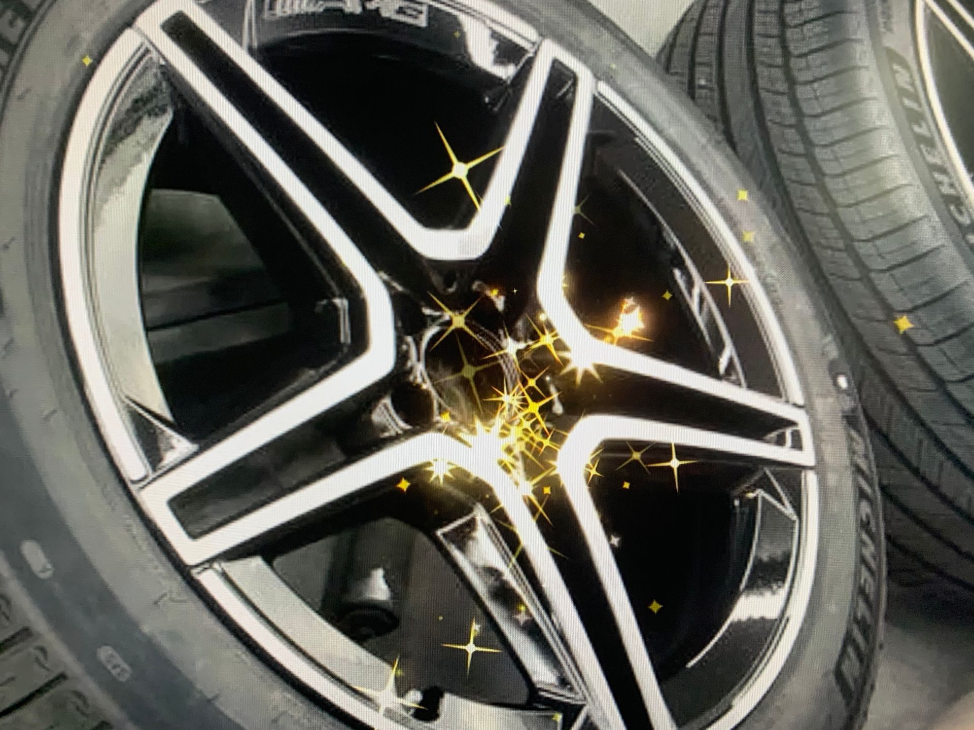 Black and silver alloy car wheel with a sparkling star effect