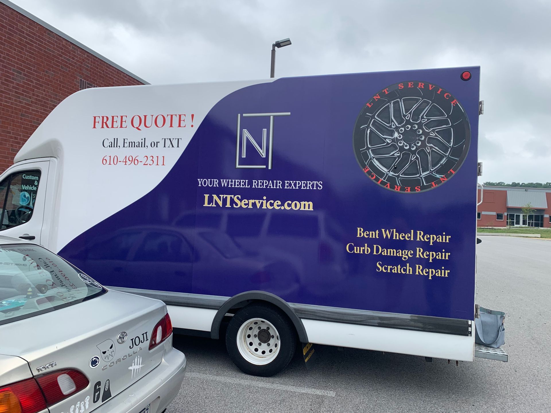 Purple N1 Services van with plumbing and drain cleaning ads parked beside a silver car.