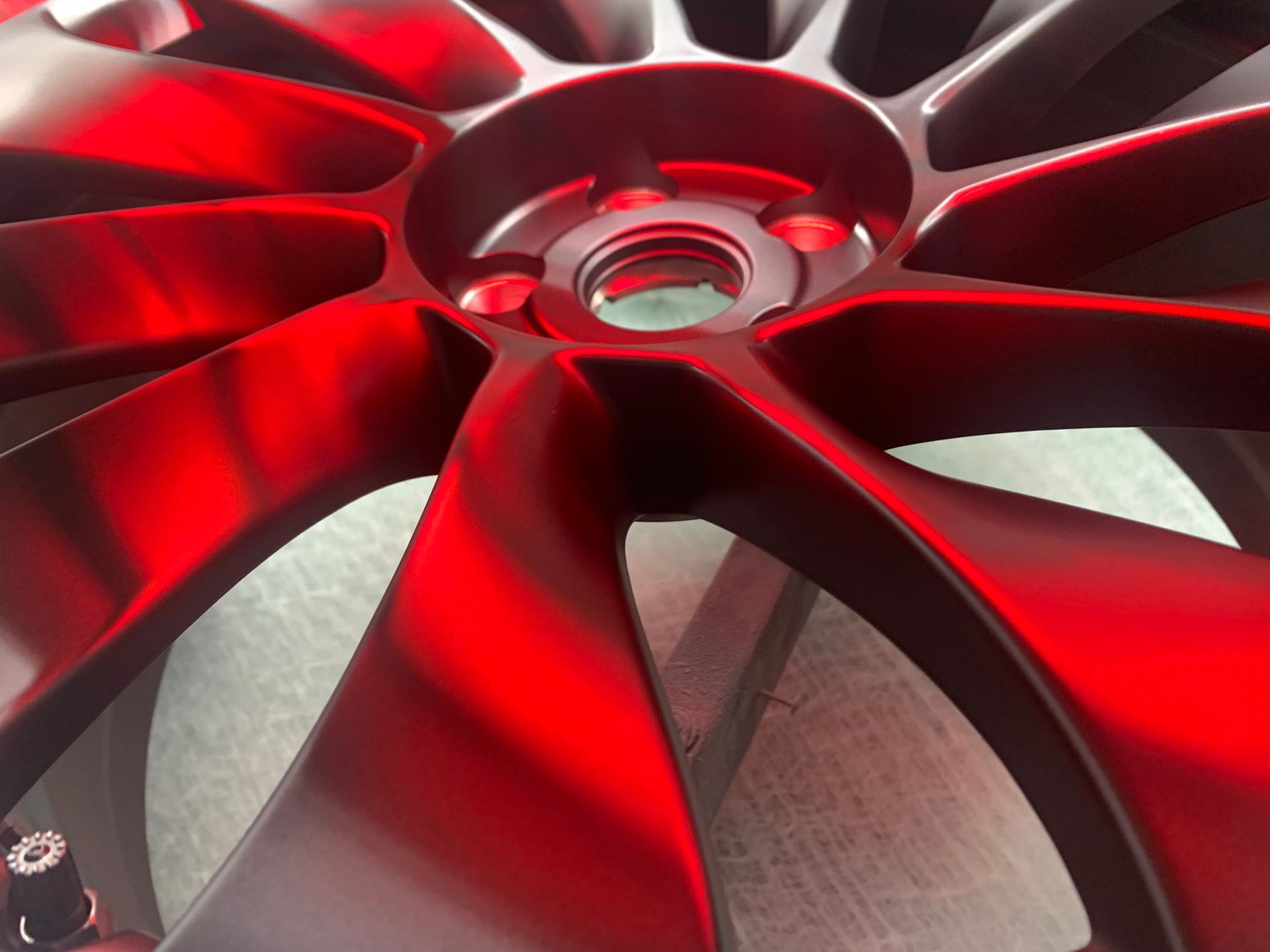 Close-up of a glossy red alloy wheel rim with black accents