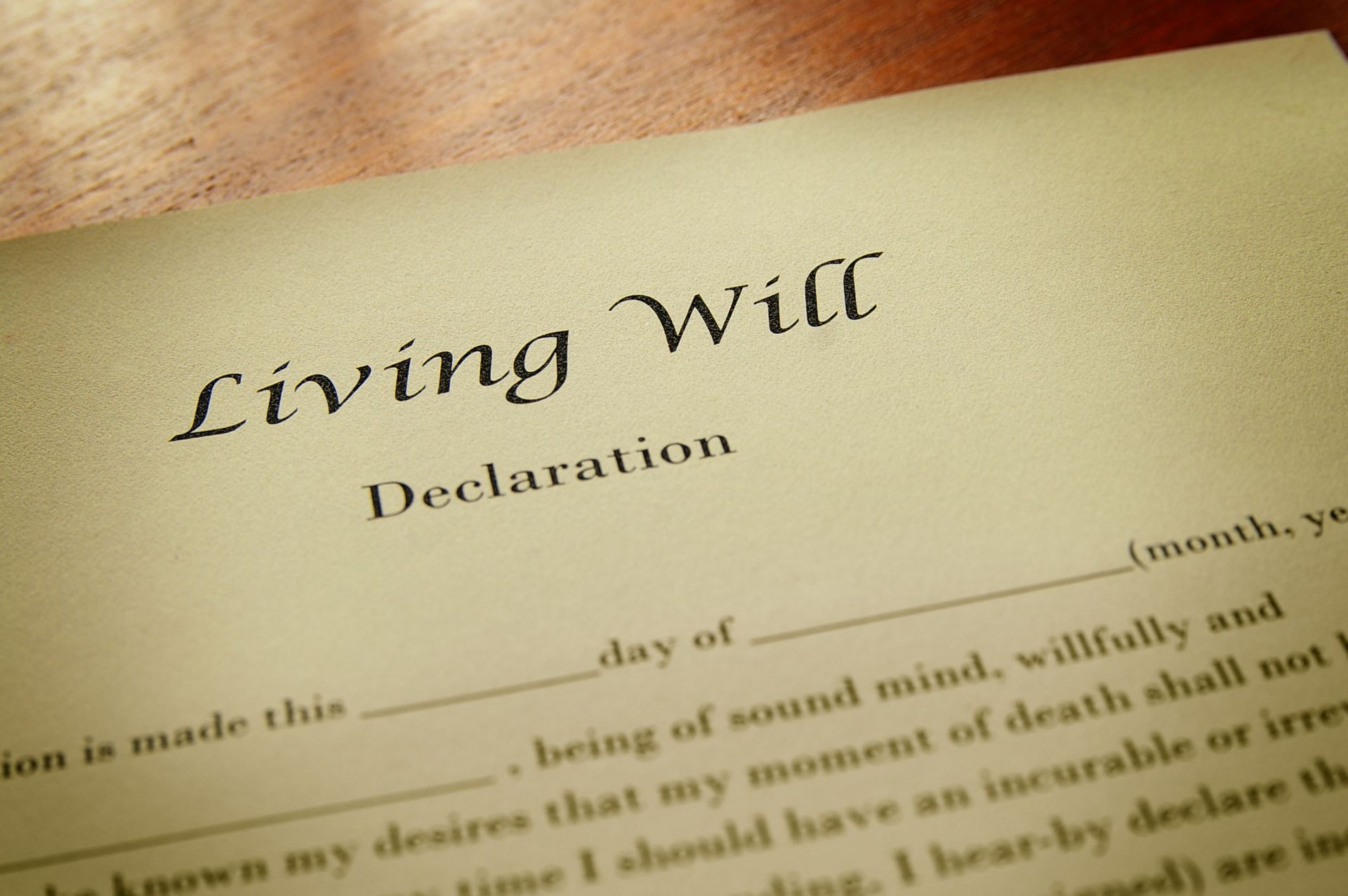 Living Will document; cream-colored paper with declaration text in a cursive font, on a wooden surface.