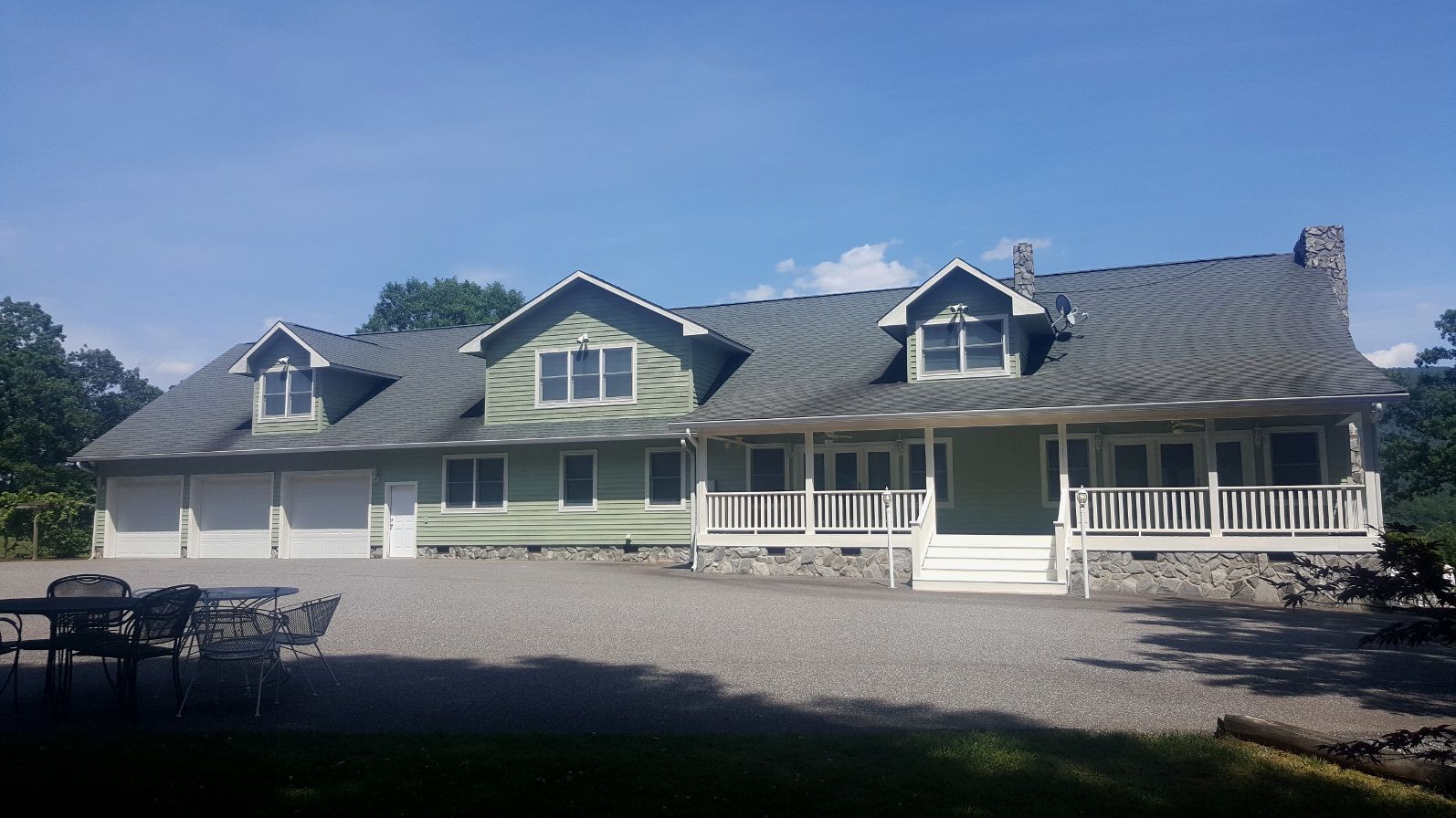 A large house with a gray roof and green siding