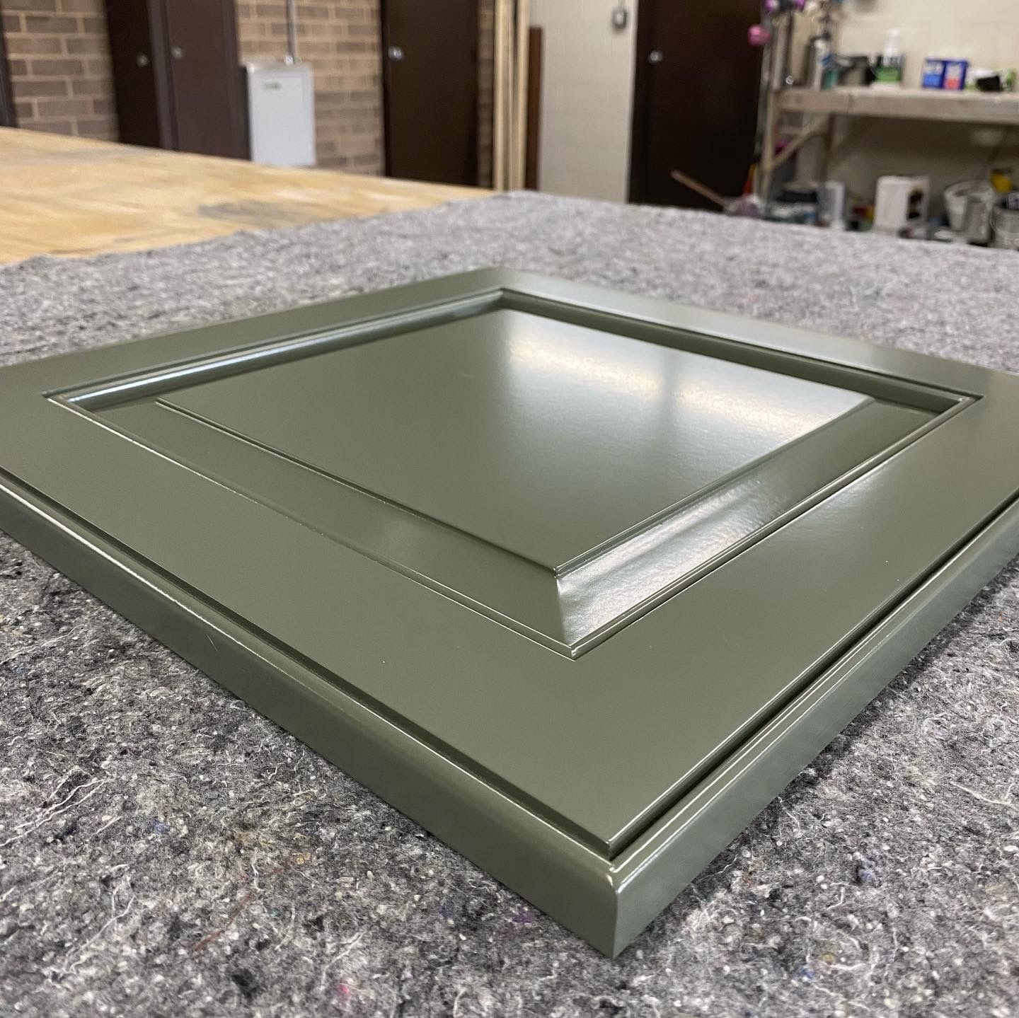 A green picture frame is sitting on a table.