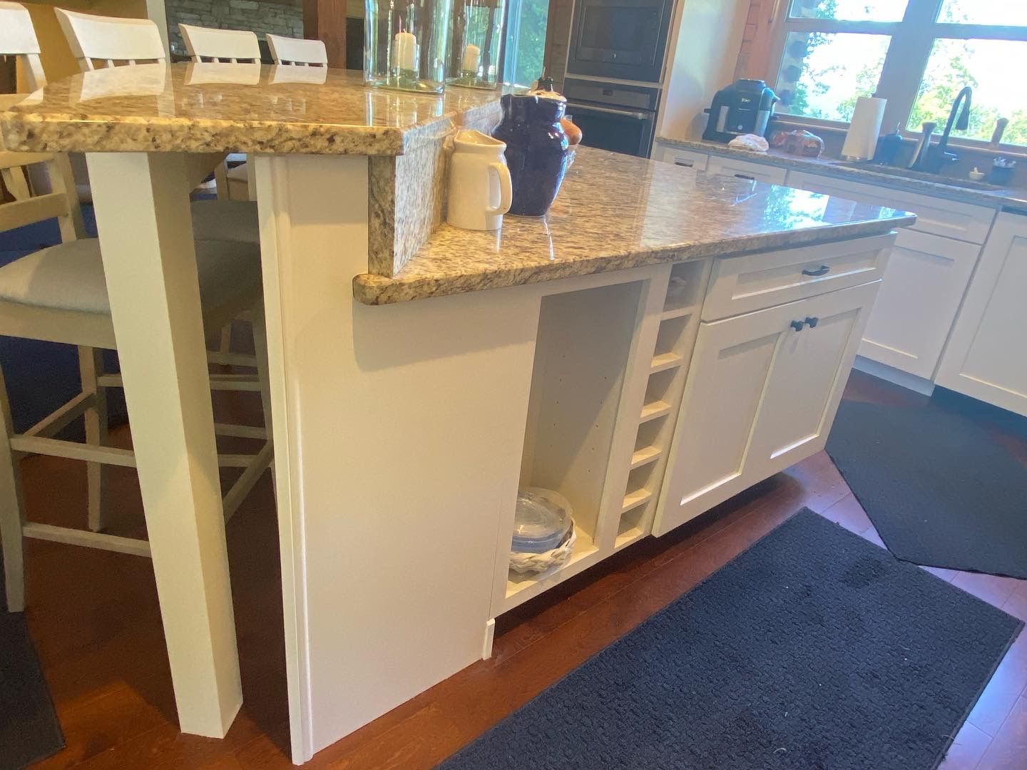 A kitchen with white cabinets and a granite counter top.