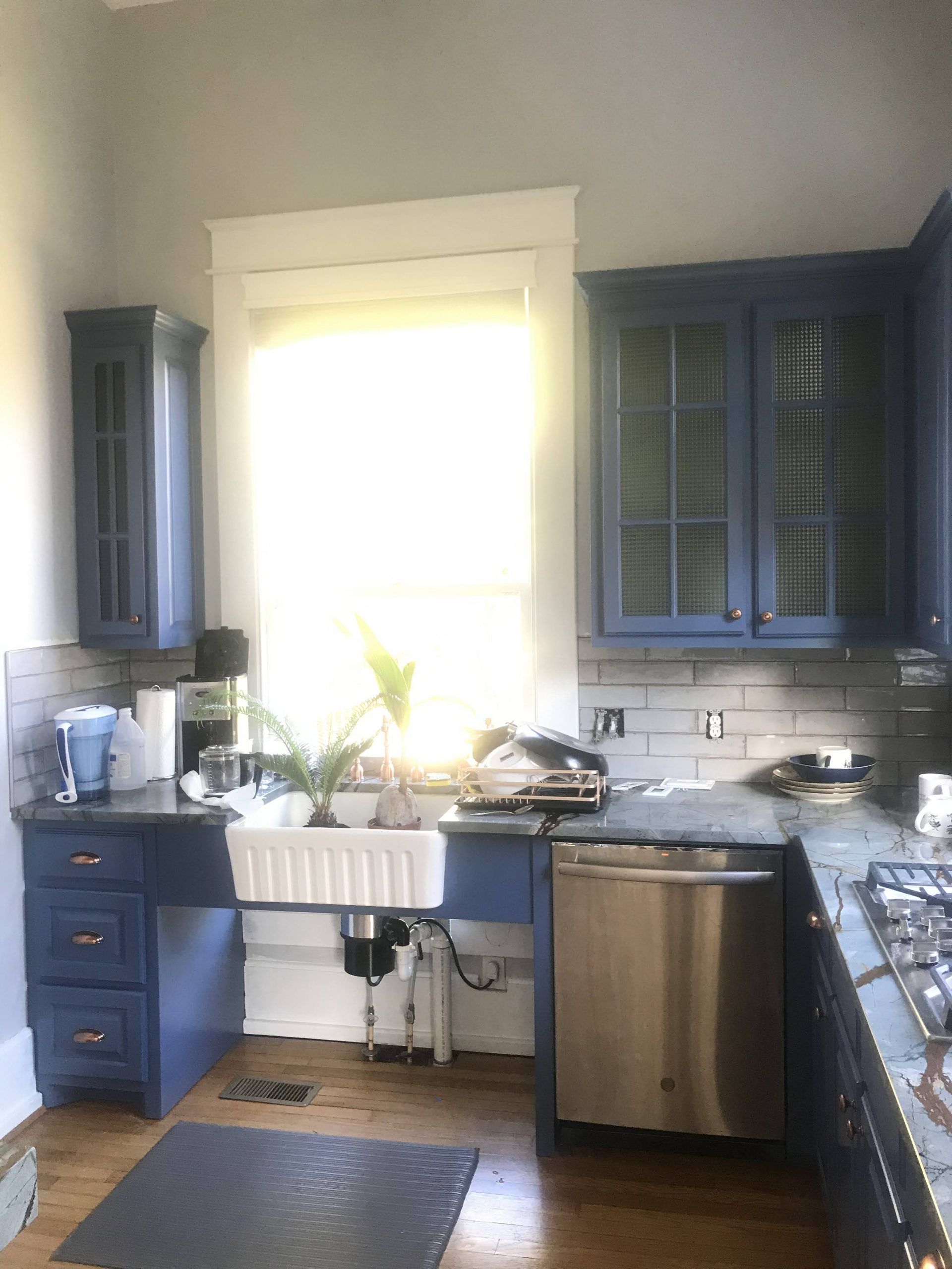 A kitchen with blue cabinets and a white sink
