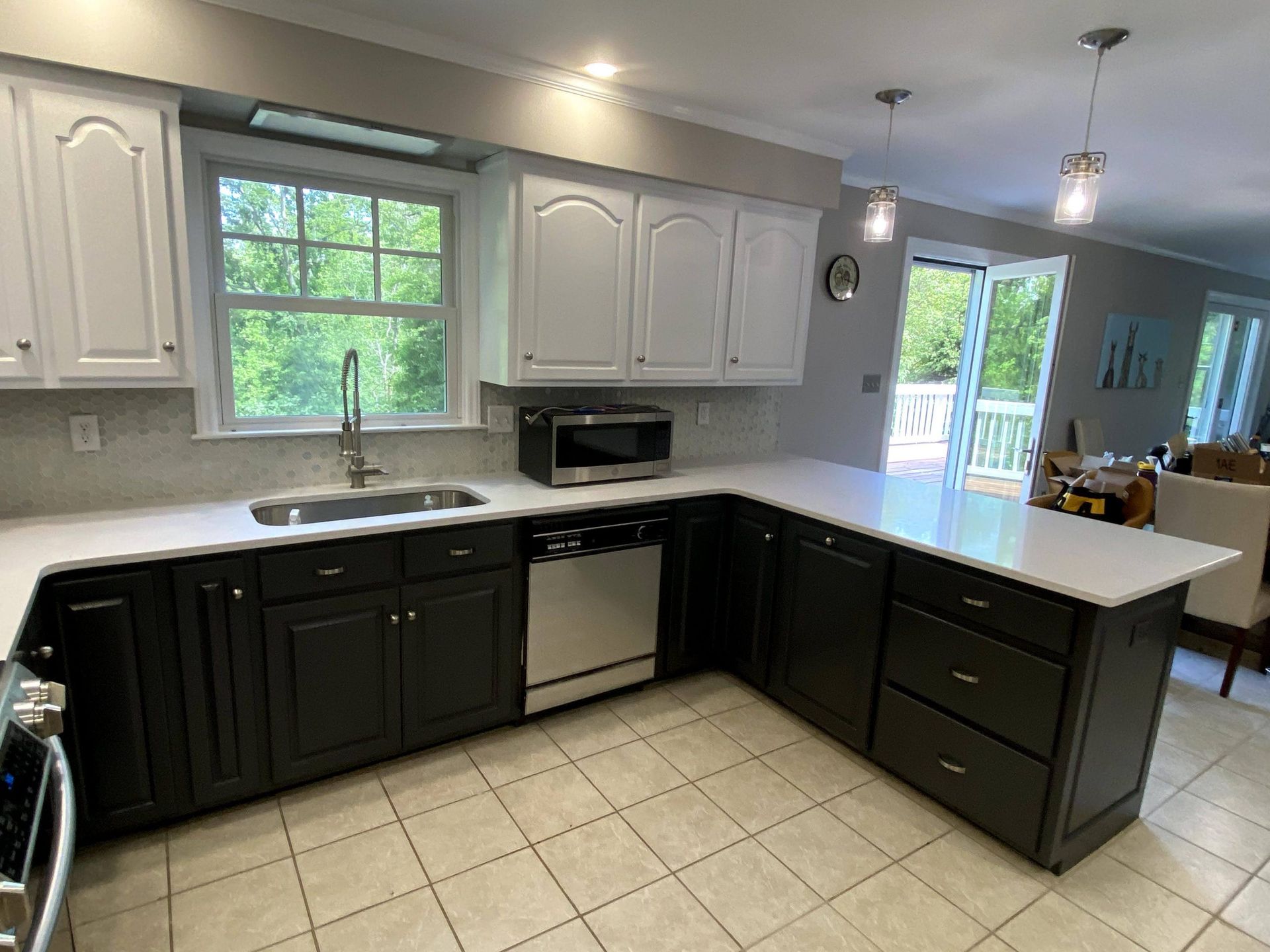 A kitchen with black cabinets and white counter tops.