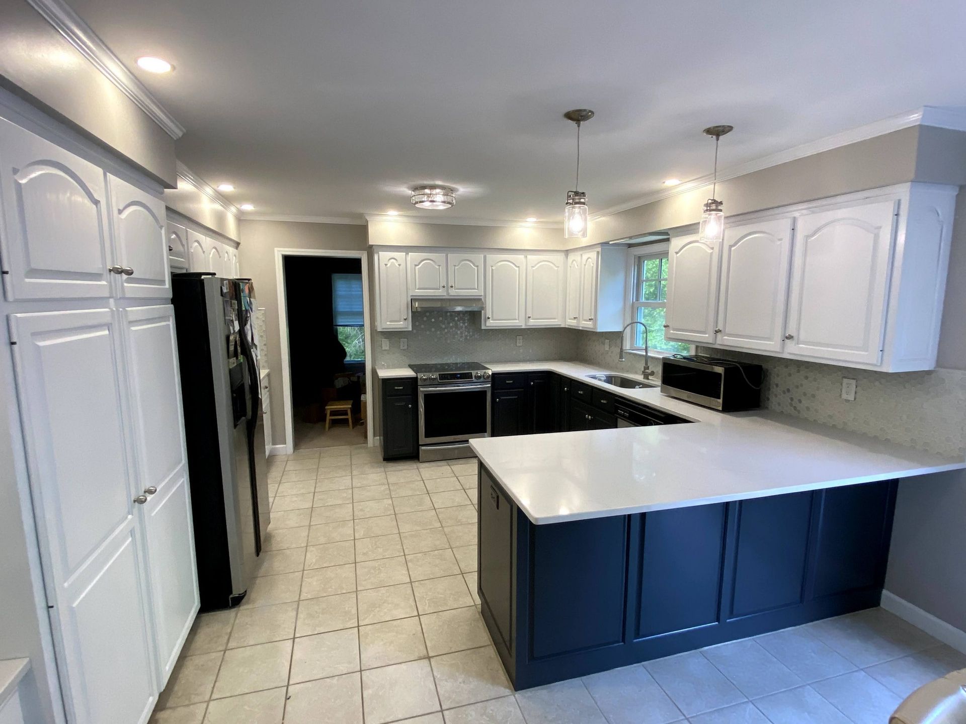 A kitchen with white cabinets and blue counter tops.