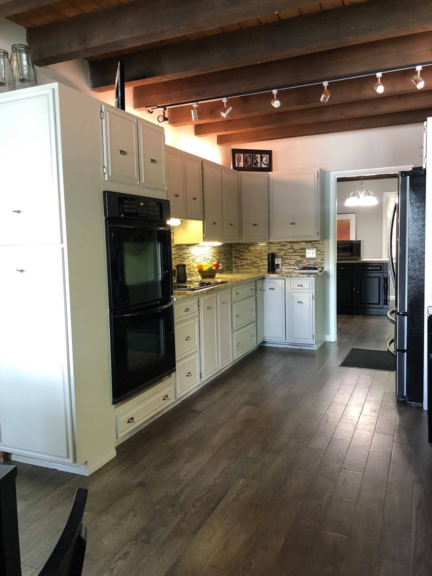 A kitchen with white cabinets and a black oven
