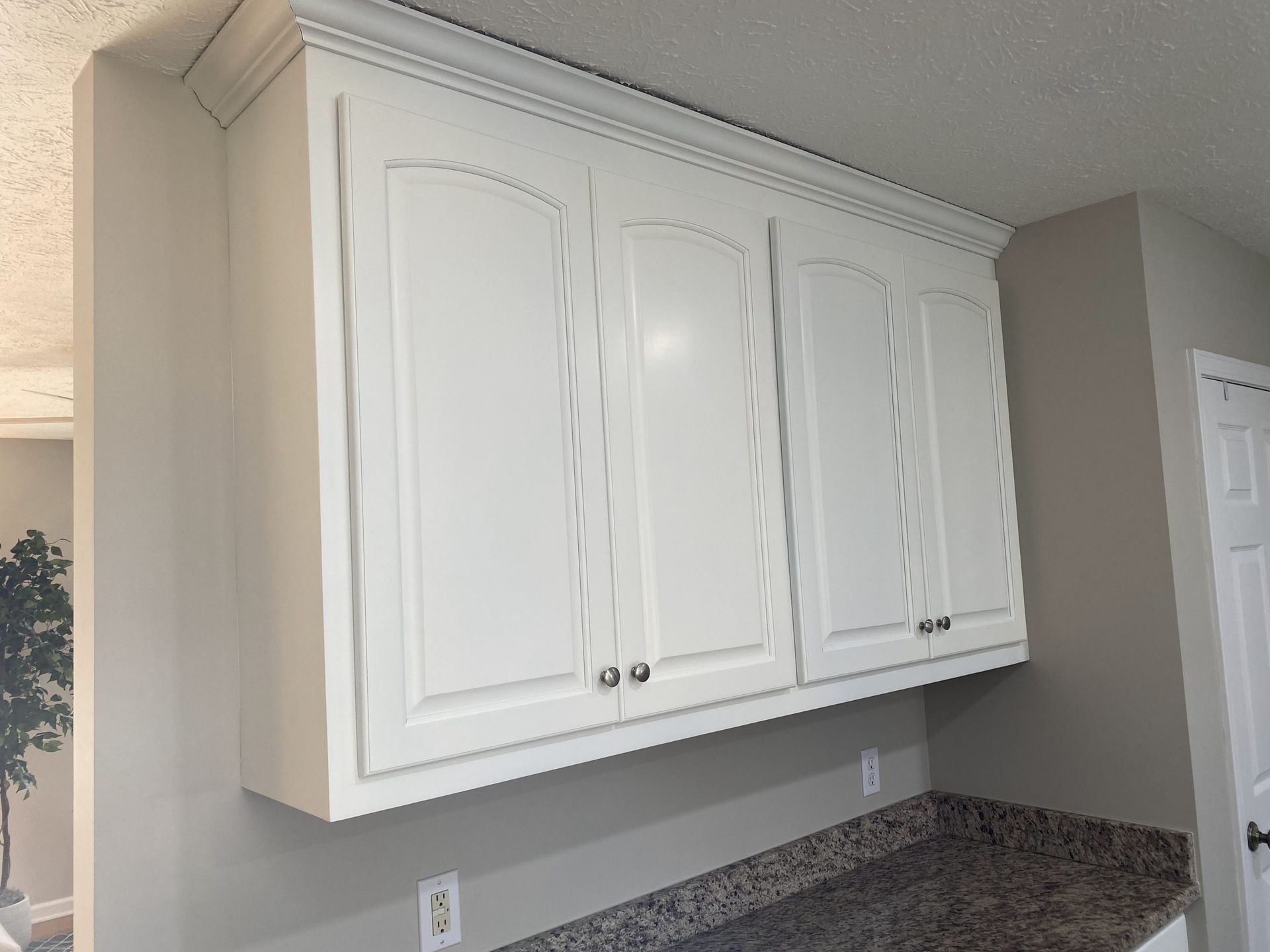 A kitchen with white cabinets and granite counter tops