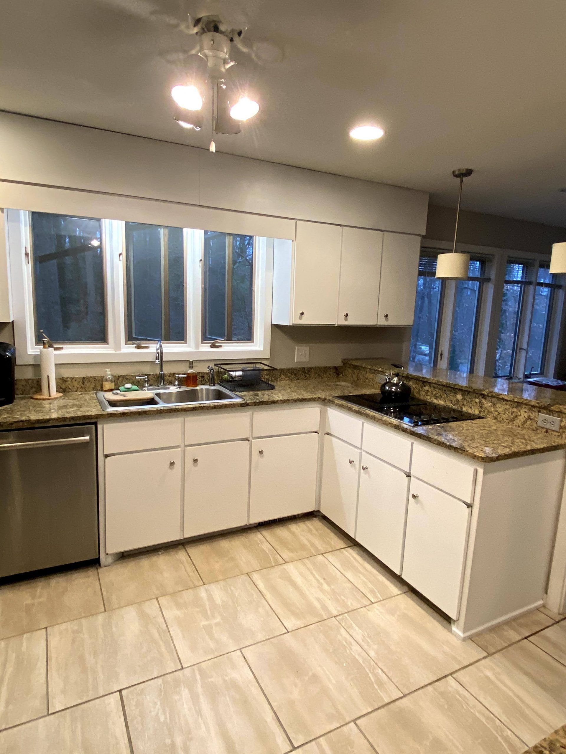 A kitchen with white cabinets and granite counter tops