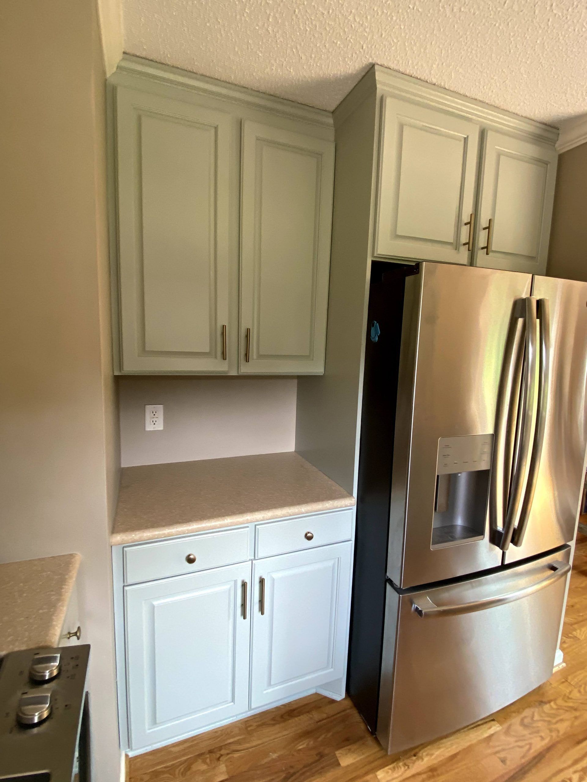 A kitchen with stainless steel appliances and white cabinets