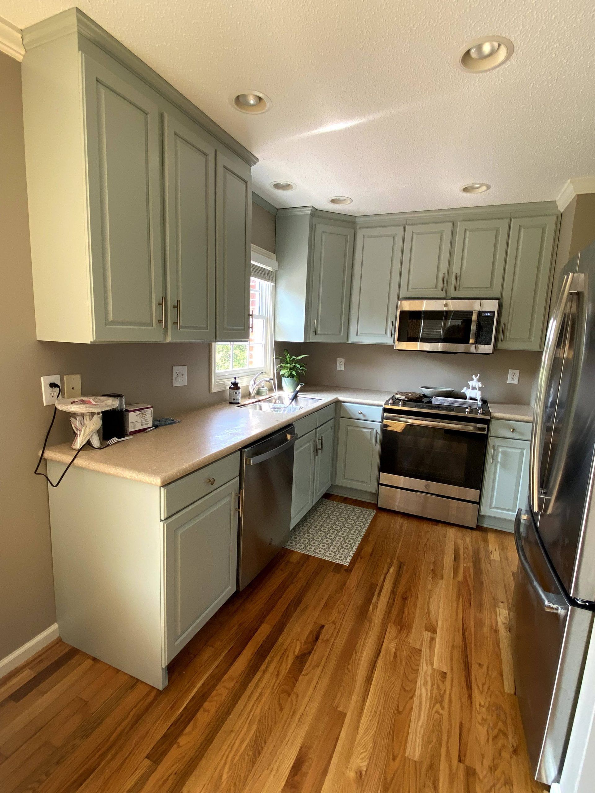 A kitchen with stainless steel appliances and wooden floors
