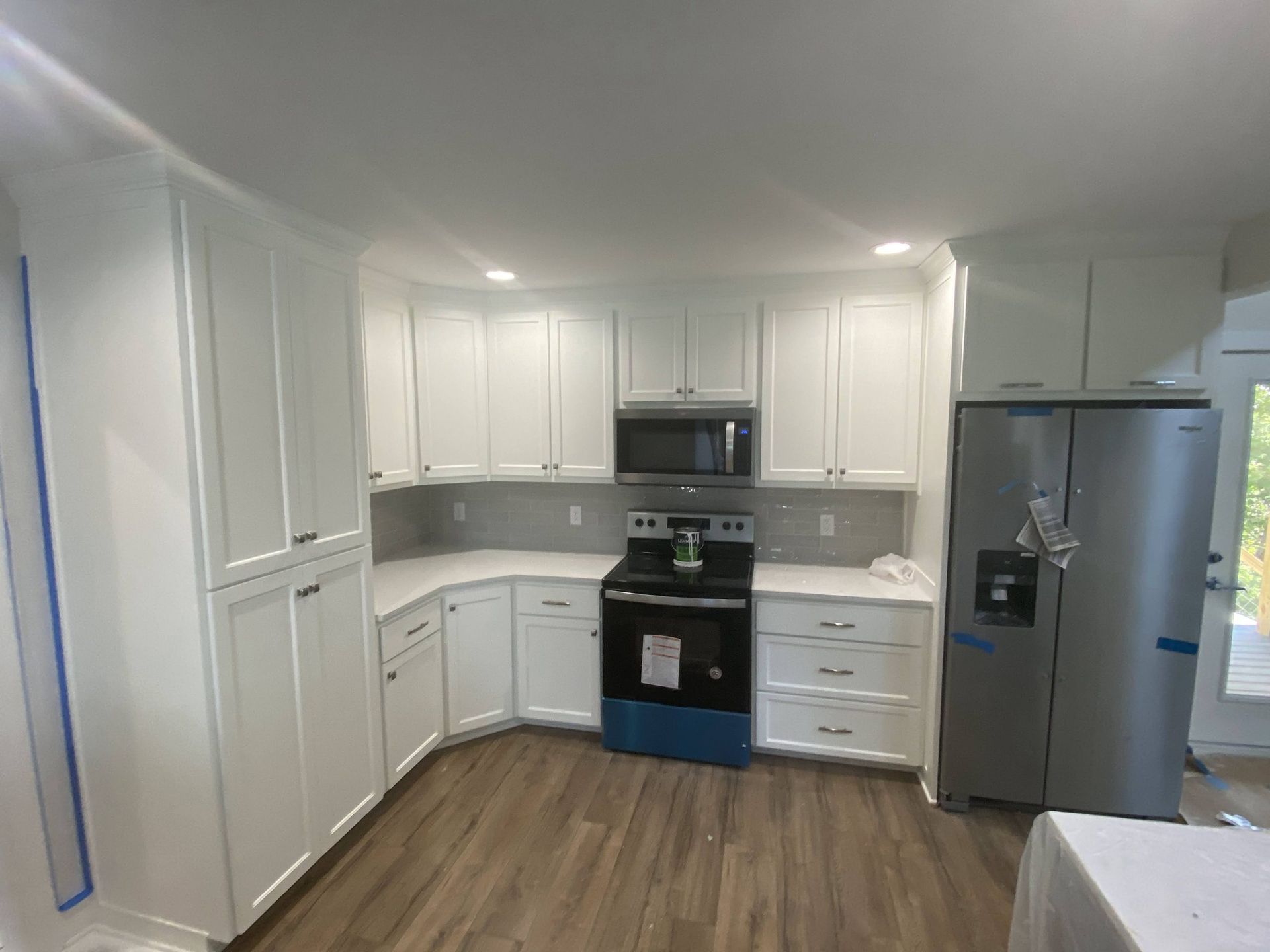 A kitchen with white cabinets and stainless steel appliances