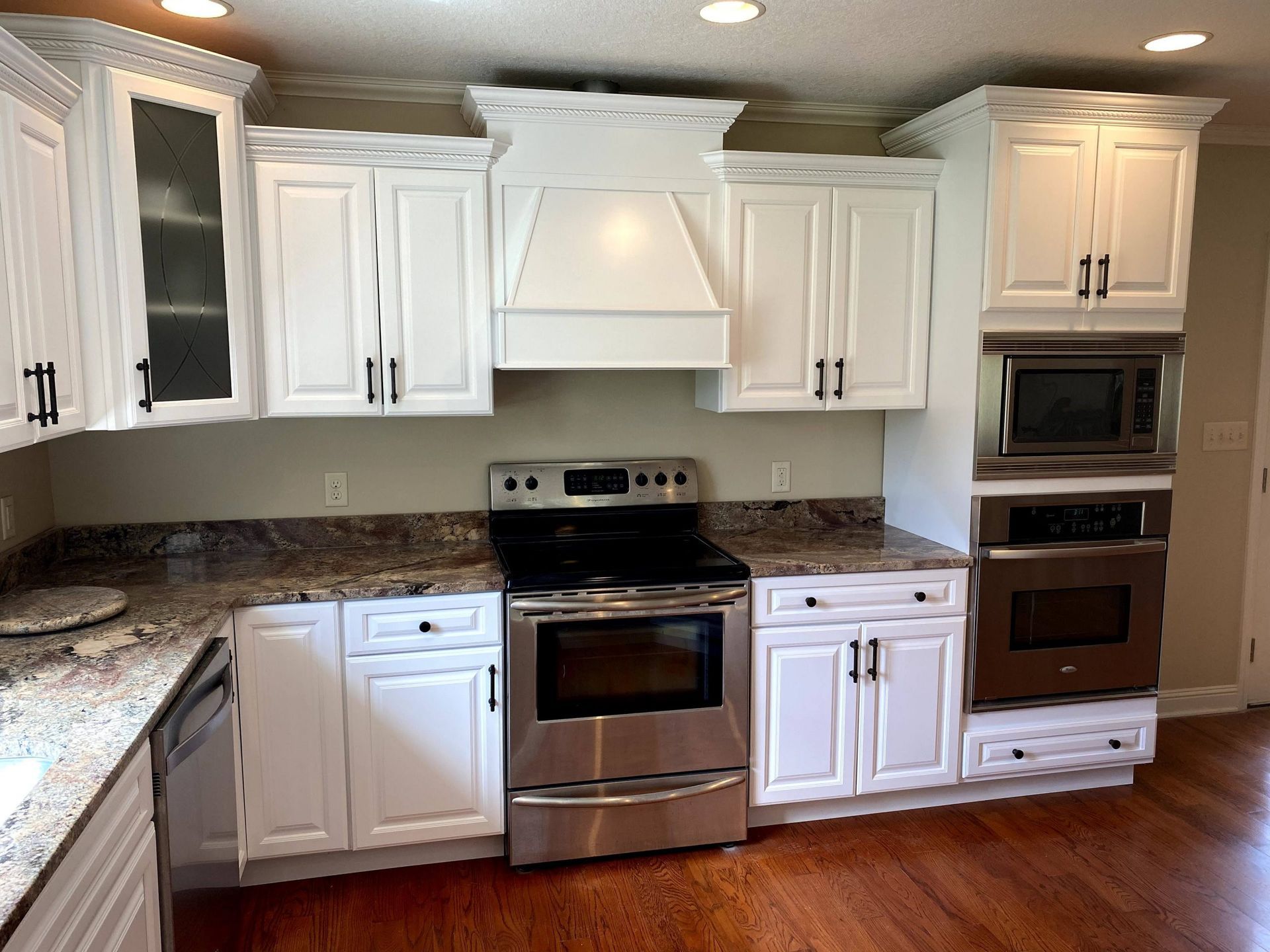 A kitchen with white cabinets and stainless steel appliances