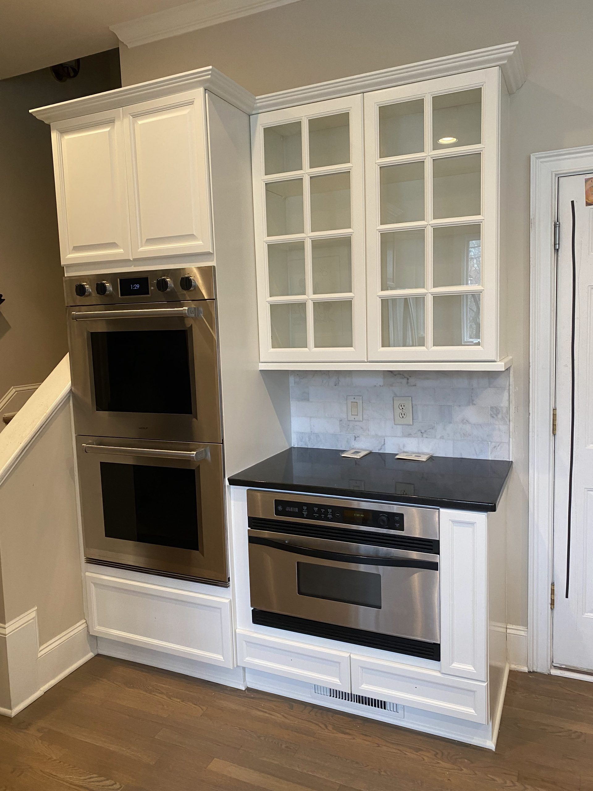 A kitchen with stainless steel appliances and white cabinets.