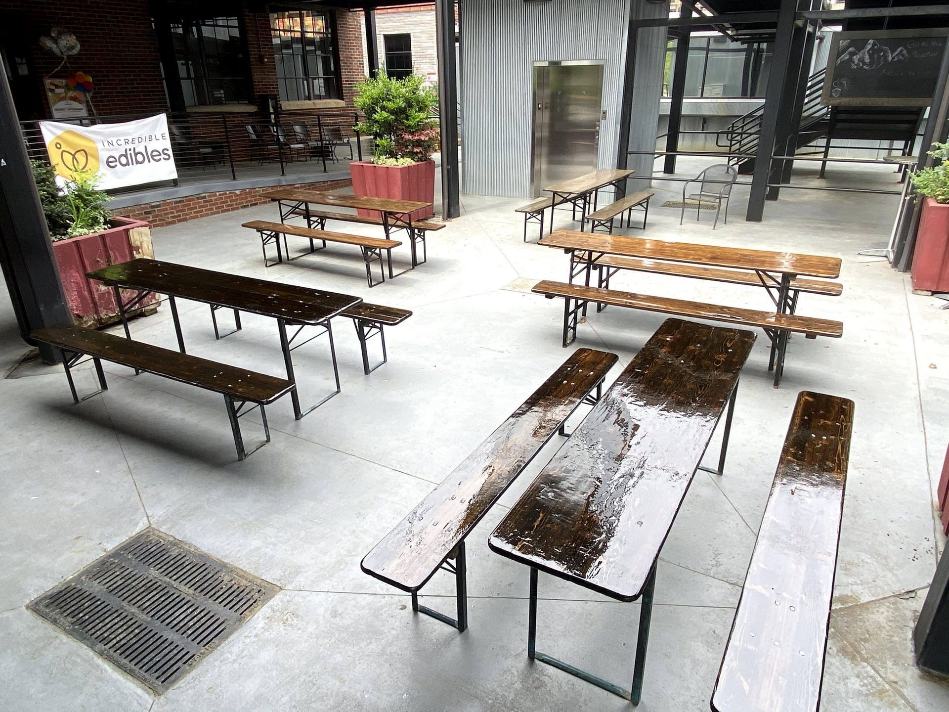A row of wooden tables and benches in a courtyard