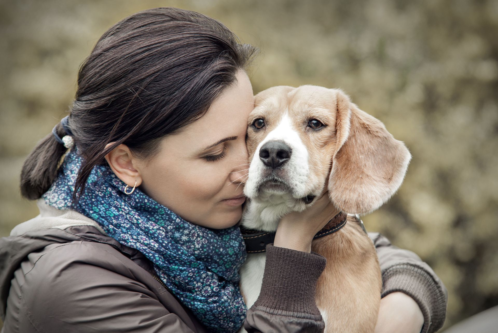 Two women, one Black and one white, laughing while embracing outdoors.