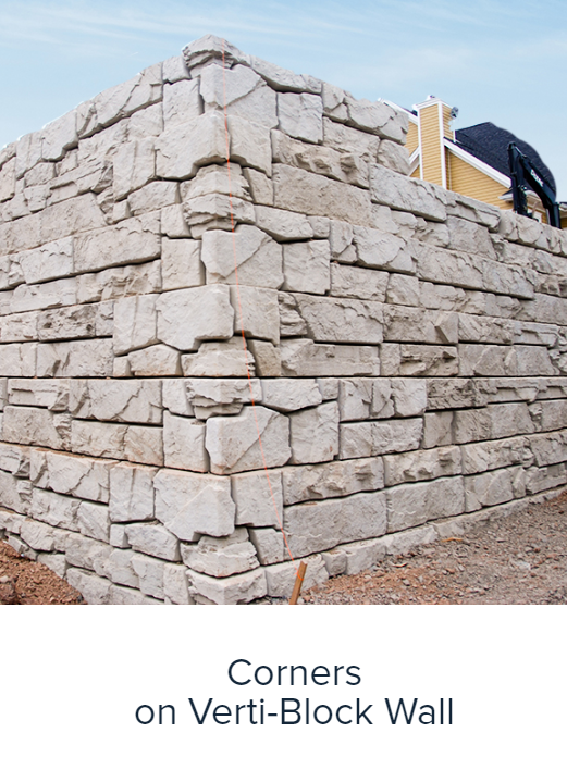 Corner detail of a beige verti-block retaining wall with stacked stone blocks.