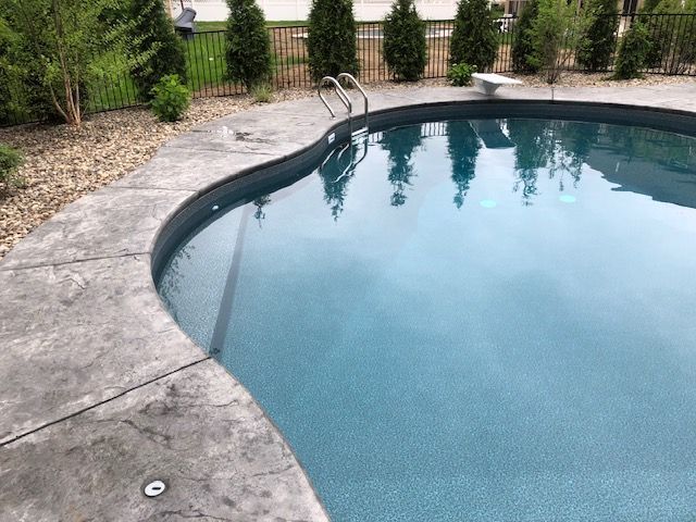a large swimming pool with trees reflected in the water .