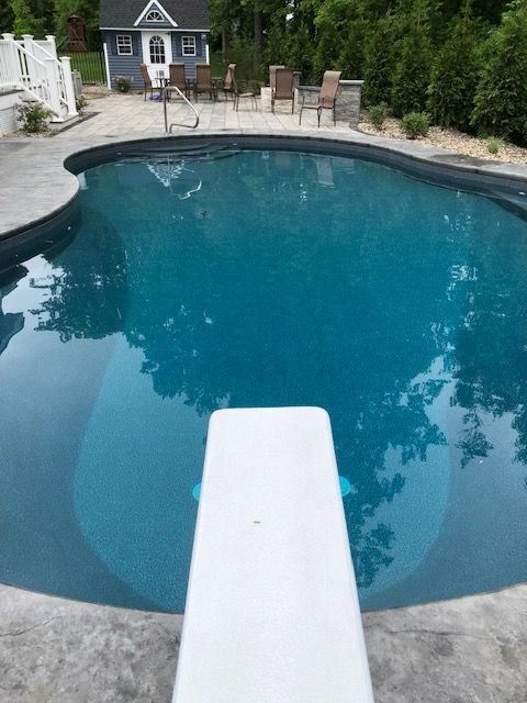 a large swimming pool with a diving board in the middle