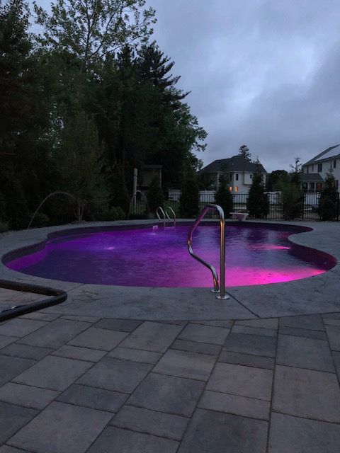 a swimming pool is lit up with purple lights