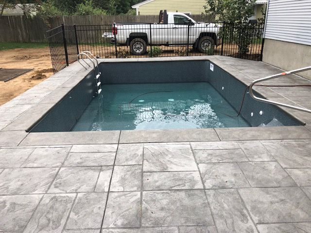 a white truck is parked next to a swimming pool .