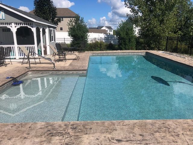a large swimming pool with a gazebo in the background .