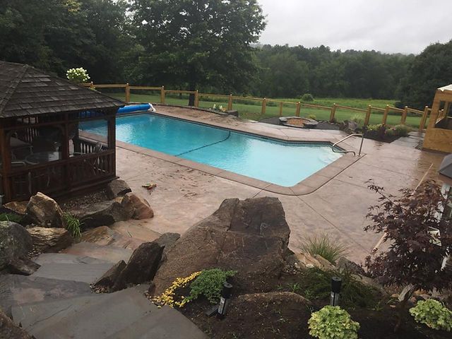 A large swimming pool with a gazebo in the background