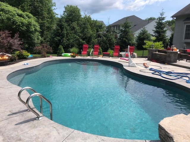 a large swimming pool surrounded by chairs and trees