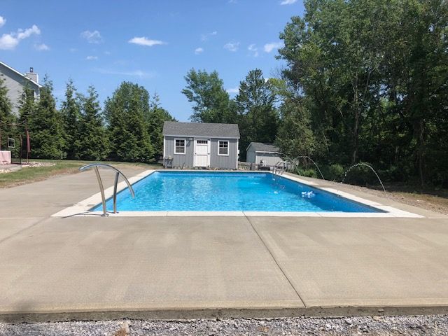 a large swimming pool is in the backyard of a house .