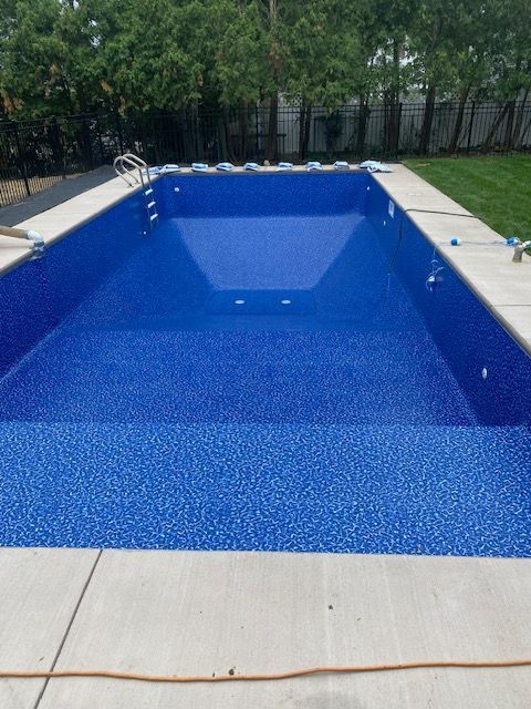a large swimming pool with blue tiles on the floor