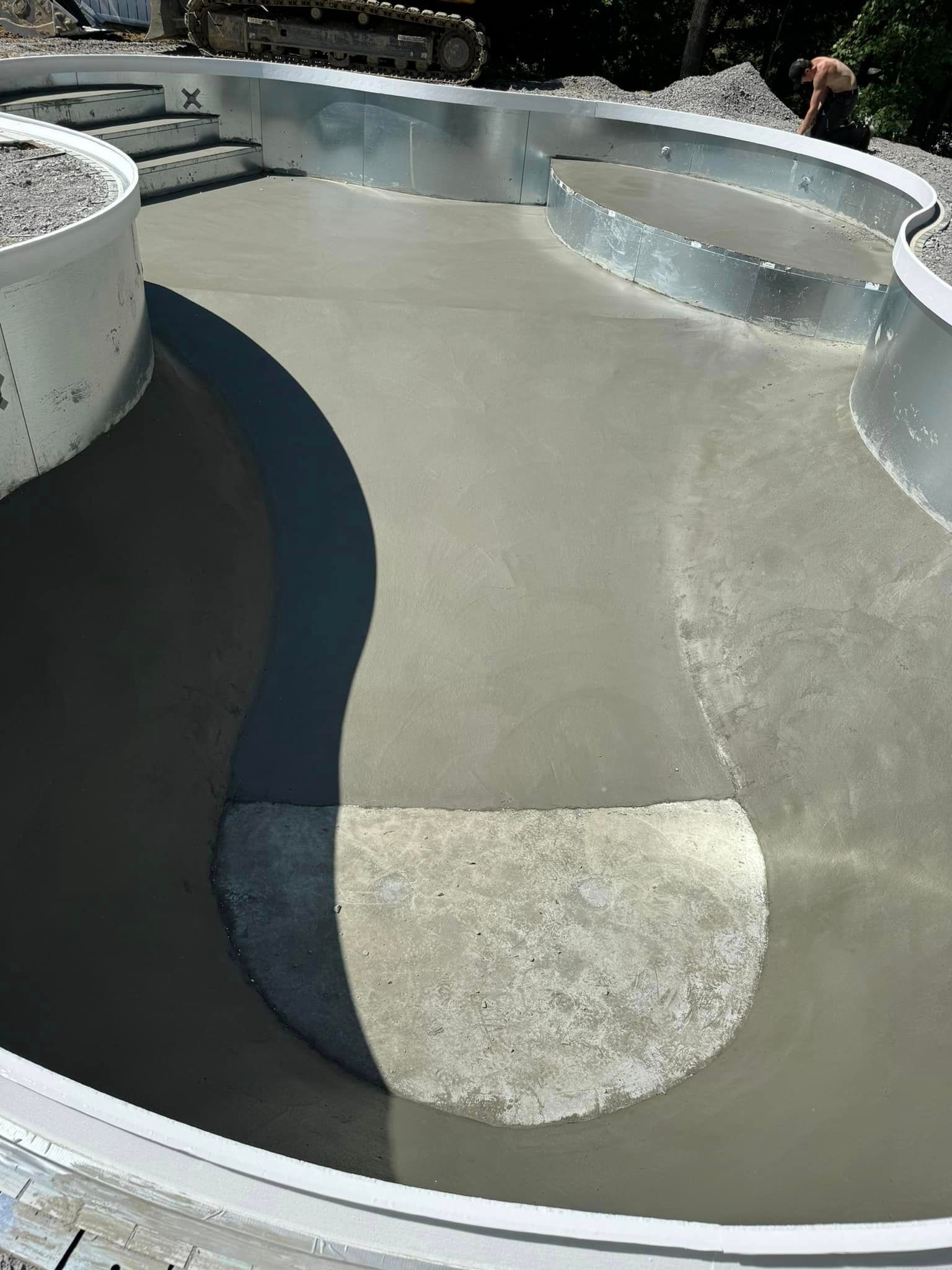 A man is standing in the middle of a concrete pool.