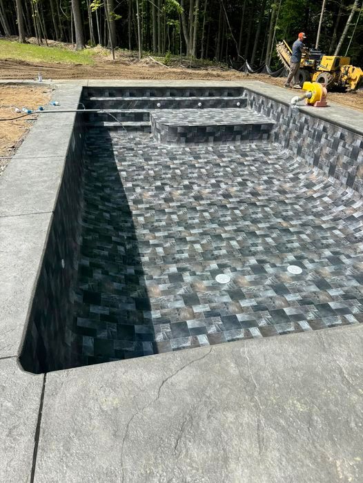 A large swimming pool is being built in a backyard.