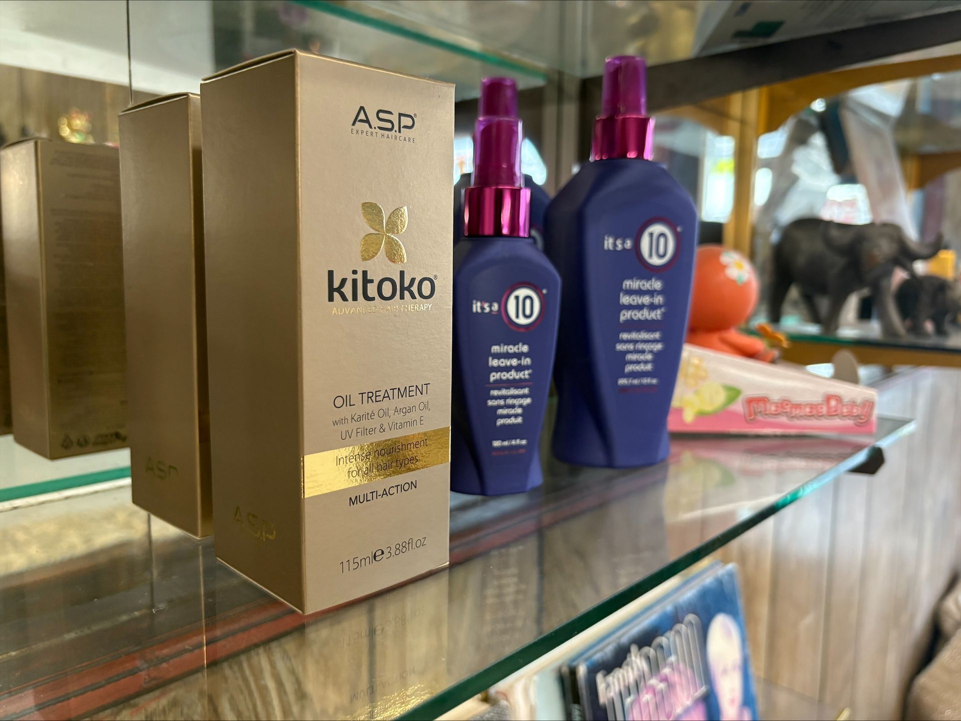 Kitoko ASP hair products on a shelf: boxes and bottles in gold, purple, and blue.