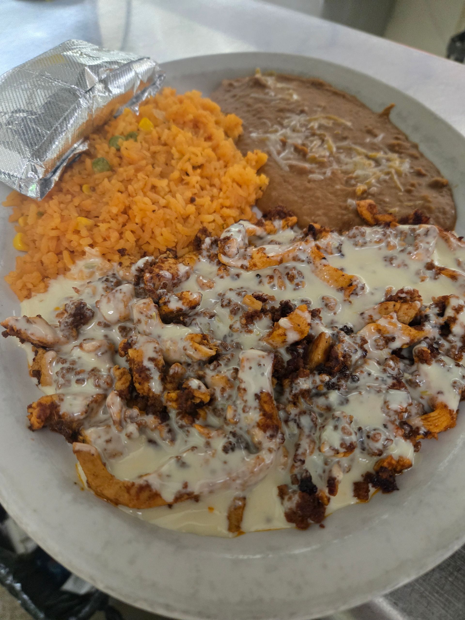 A plate of mexican food with rice and beans on a table.