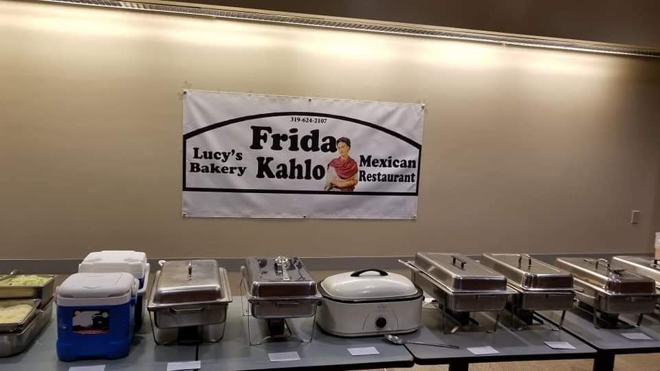 A sign for frida bakery kahlo hangs above a buffet line