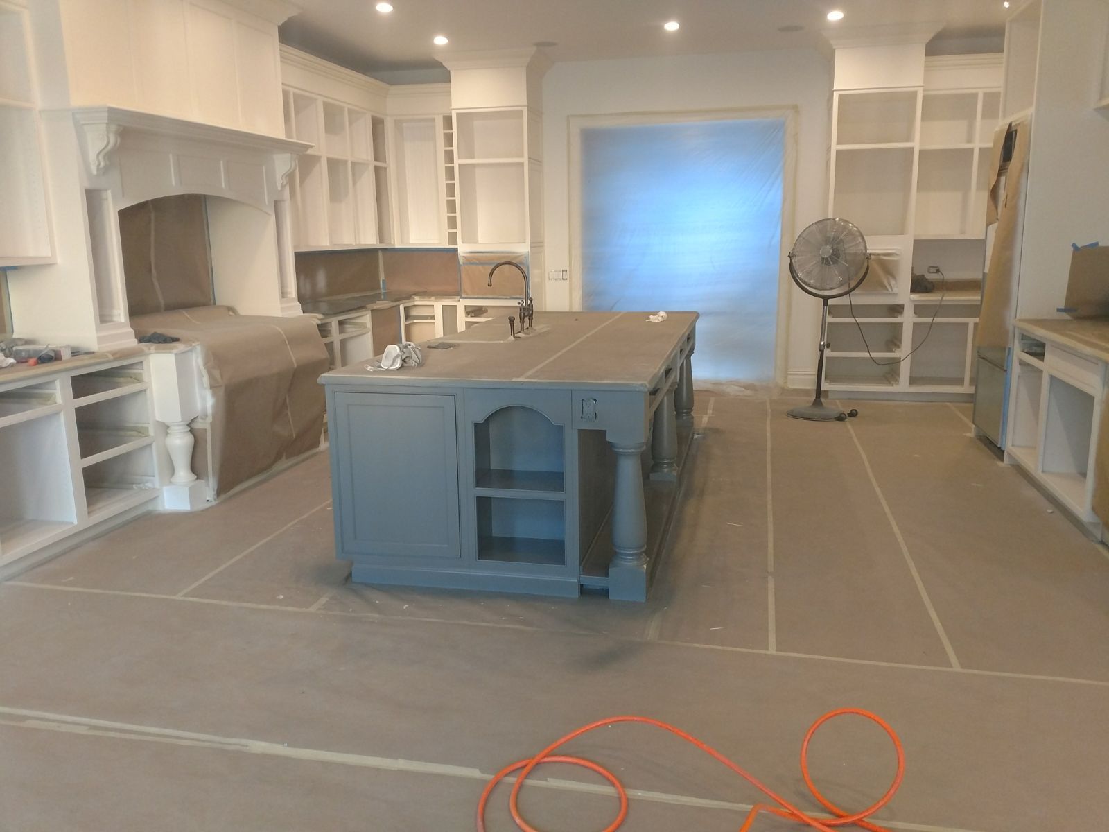 A kitchen under construction with a large island in the middle of the room.