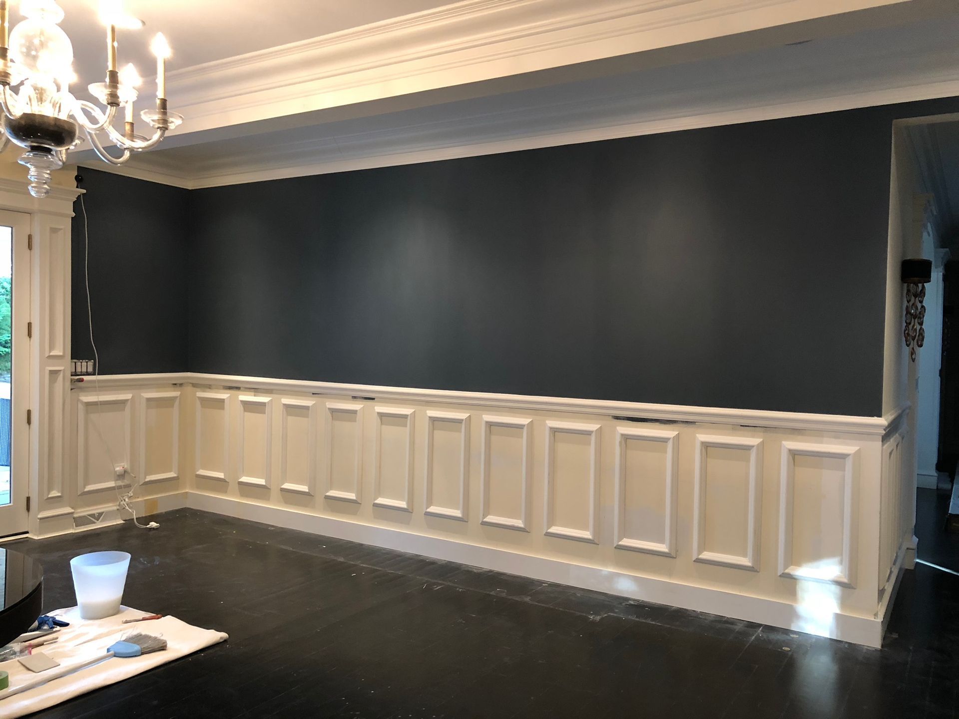 A living room with a large wall and a chandelier.