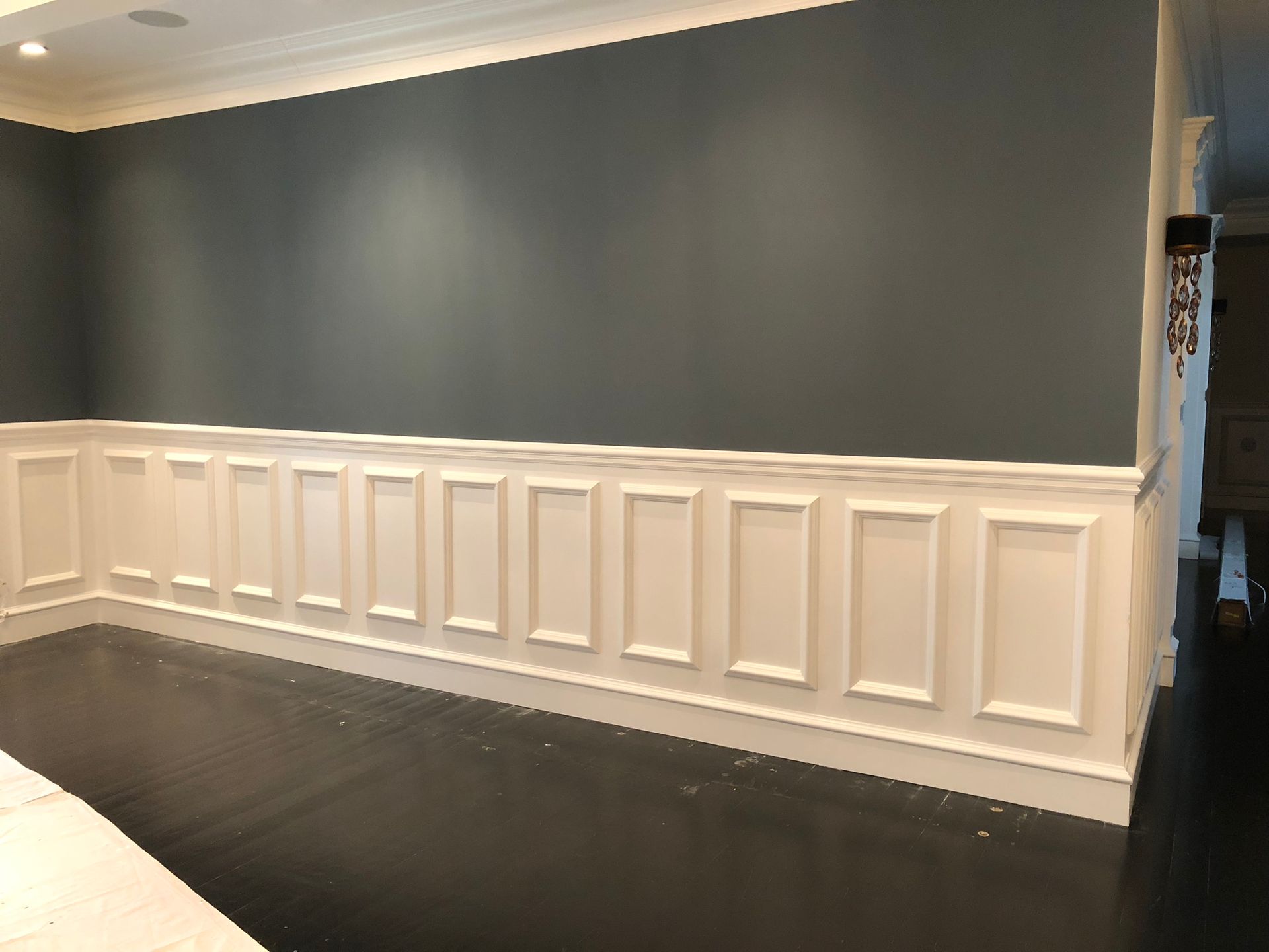 A room with blue walls and white trim and a black floor