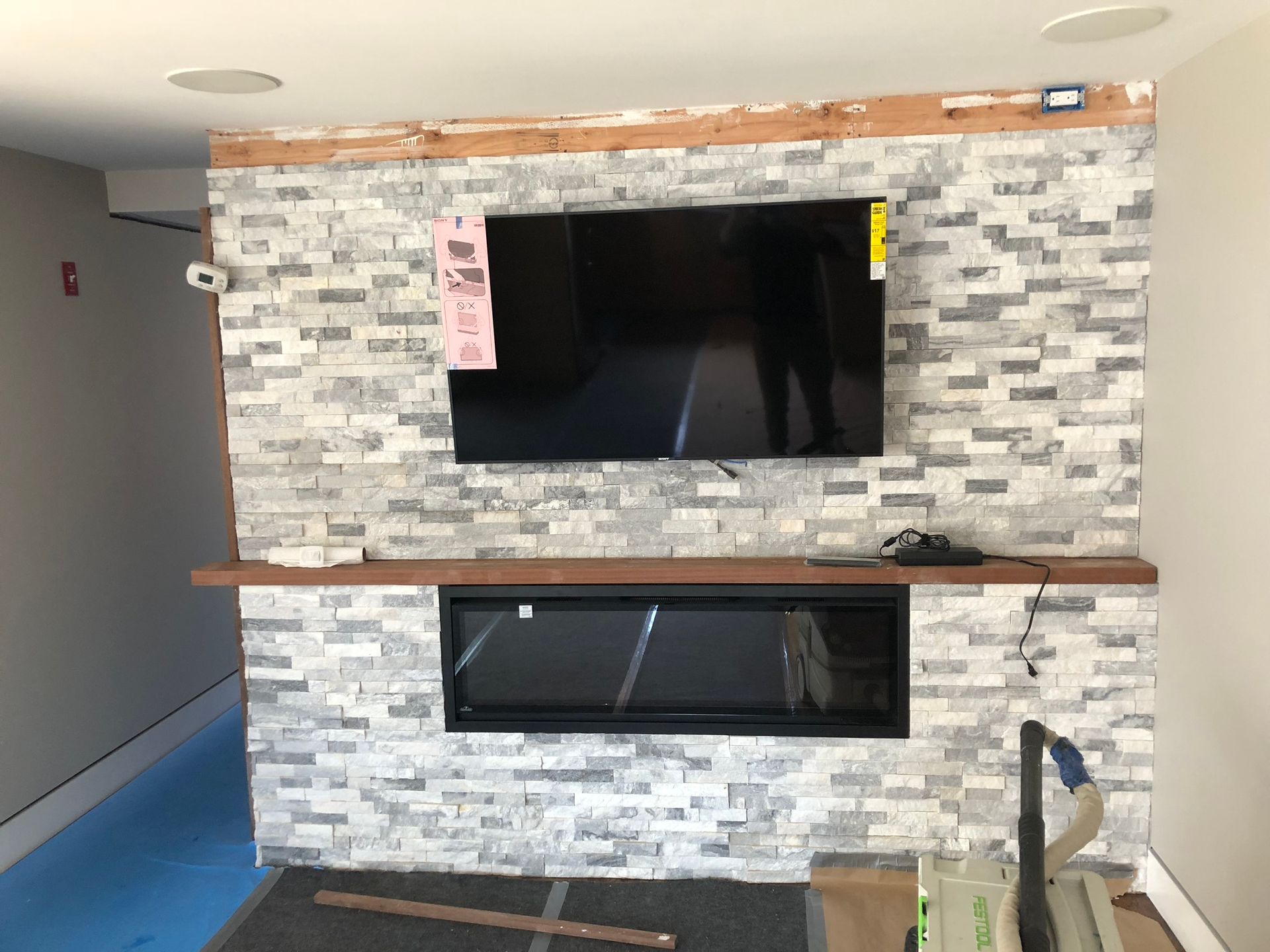 A living room with a fireplace and a flat screen tv on the wall