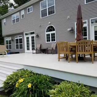 There is a large deck with a table and chairs on it.