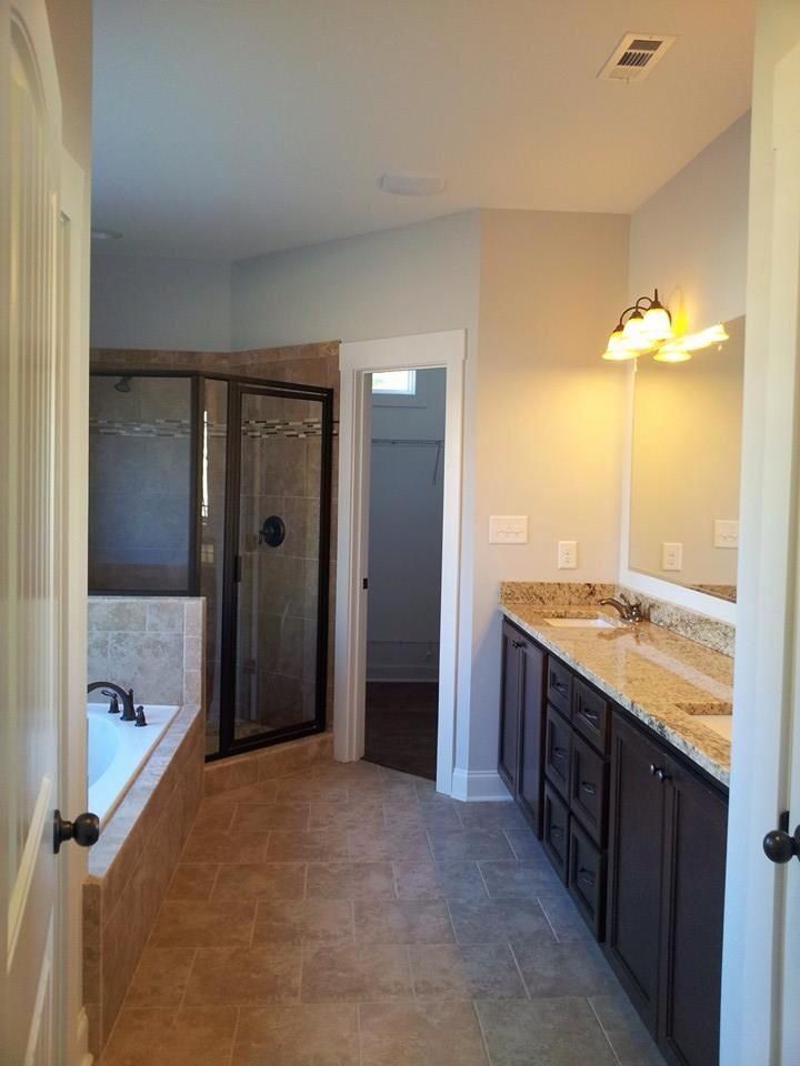 Bathroom with a tub, shower, vanity with double sinks, and a walk-in closet.