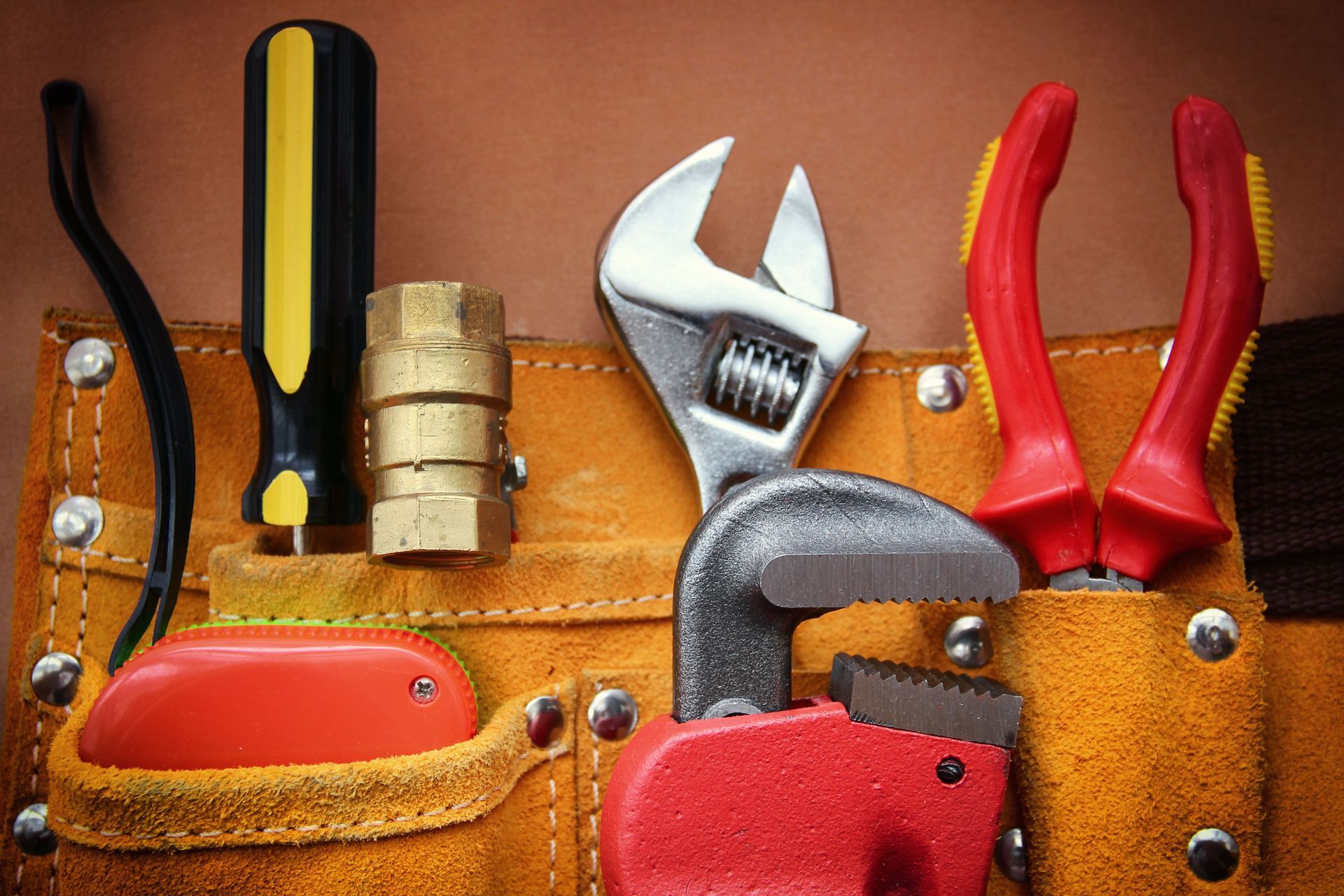 Tool belt holding various tools, including a screwdriver, wrench, and pliers.