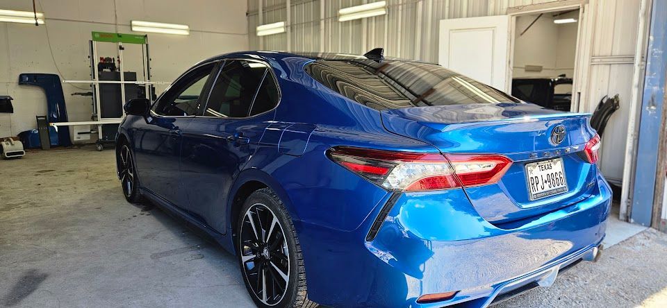 Blue Toyota Camry in a garage.