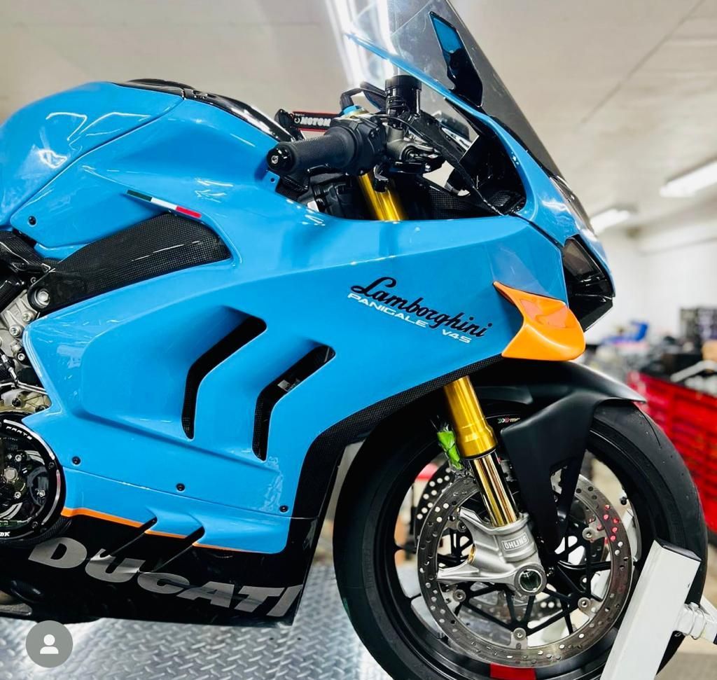 Blue and orange Lamborghini-branded Ducati motorcycle with gold suspension.