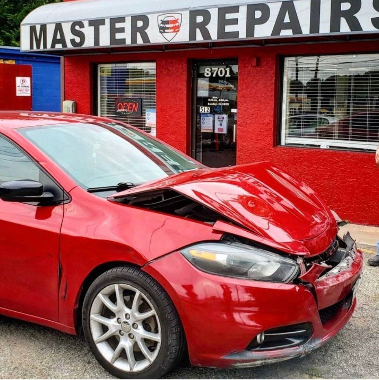 Red car with front-end damage in front of 
