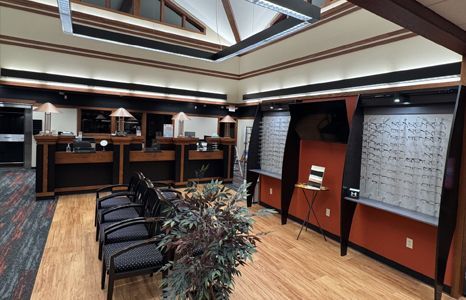 A waiting room with a lot of chairs and glasses on the wall.