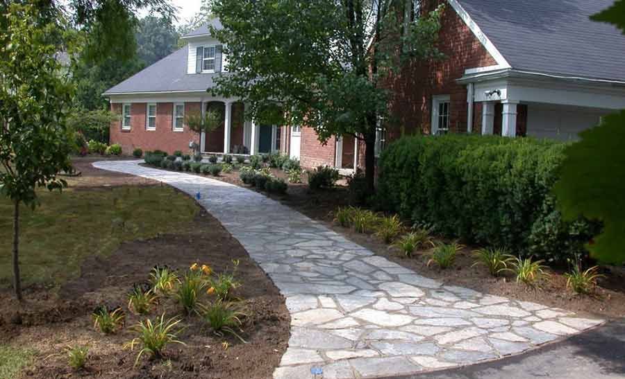 A brick house with a stone walkway leading to it.